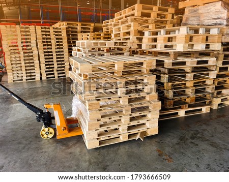 Worker driving forklift to loading and unloading wooden pallets from truck to warehouse cargo storage, shipment in logistics and transportation industrial, wood pallets stack Royalty-Free Stock Photo #1793666509