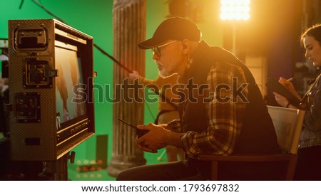 Director Looks at Display Controls Shooting Period Drama Movie. Green Screen CGI Scene with Actors Wearing Renaissance Costumes. Crew Shooting High Budget Movie.