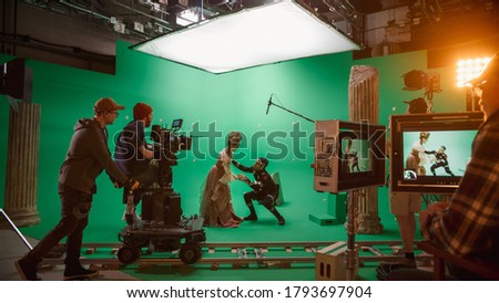On Big Film Studio Professional Crew Shooting History Costume Drama Movie. On Set: Directing Green Screen Scene with Beautiful Lady Wearing Renaissance Costume Meets Actor Playing Monster