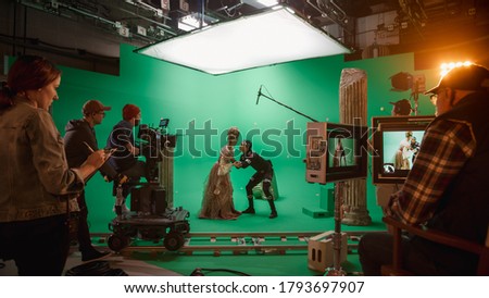 On Big Film Studio Professional Crew Shooting History Costume Drama Movie. On Set: Directing Green Screen Scene with Beautiful Lady Wearing Renaissance Costume Meets Actor Playing Monster
