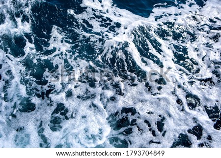 Top down aerial view of sea water surface. White foam waves texture as natural background.