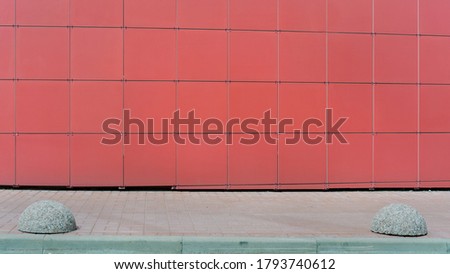 red wall of modern office building with empty space for advertising information under sidewalk of city street front view