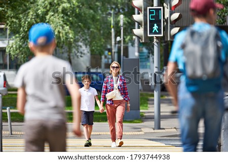 Mother and child walk on pedestrian crossing