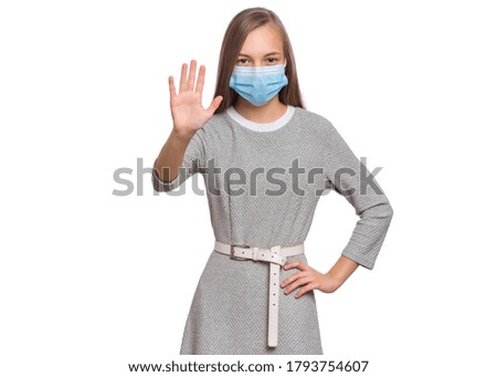 Concept of coronavirus quarantine. Child wearing medical protective face mask during flu virus, making stop gesture. COVID-19 - home self isolation. Teen Girl doing stop sign, isolated on white.