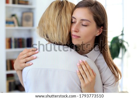 Concerned middle aged mother and adult daughter sit on couch having serious conversation, listen to her sharing problems Royalty-Free Stock Photo #1793773510