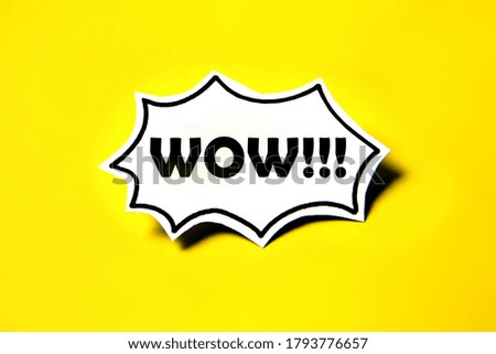 Wow speech bubble on white paper isolated on yellow paper background with drop shadow.