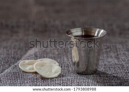 Cup with red wine, bread. Taking holy Communion. The Feast of Corpus Christi Concept.