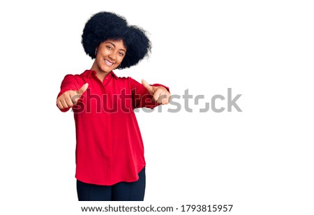 Young african american girl wearing casual clothes approving doing positive gesture with hand, thumbs up smiling and happy for success. winner gesture. 