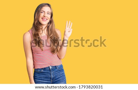 Beautiful caucasian young woman wearing casual clothes showing and pointing up with fingers number three while smiling confident and happy. 