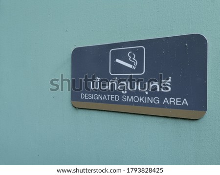 Designated smoking are and symbol white on the green warm wall and right hand side. 