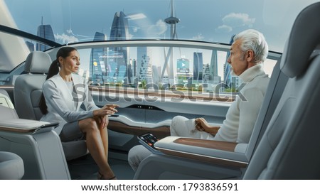 Beautiful Female and Senior Man are Having a Conversation in a Driverless Autonomous Vehicle. Futuristic Self-Driving Van is Moving on a Public Highway in a Modern City with Glass Skyscrapers.