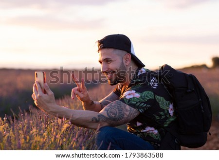 young tattooed backpacker traveling takes photos in nature