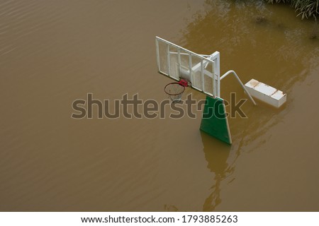 During the rainy season, heavy rain flooded the river and flooded the basketball court.