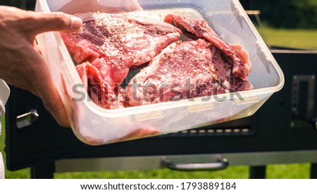 Home barbecue with charcoal in the backyard grilling steaks and other meats for carnivore diet.