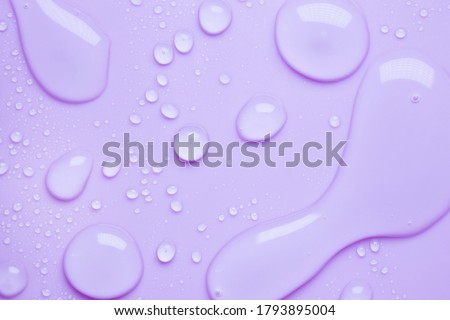 Cosmetic moisturizing liquid drops on purple lavender pastel background. Toner or lotion. Hyaluronic serum Royalty-Free Stock Photo #1793895004
