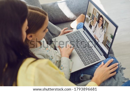 Family doctor online. Mom and little girl daughter are at home and use a video call to receive medical care online. Telemedicine concept.