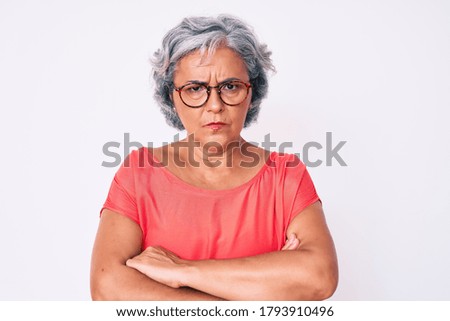 Senior hispanic grey- haired woman wearing casual clothes and glasses skeptic and nervous, disapproving expression on face with crossed arms. negative person.  Royalty-Free Stock Photo #1793910496