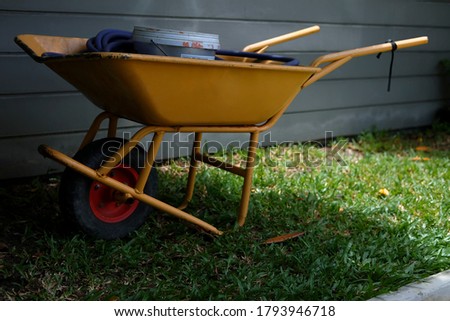 A yellow cart loaded with things on the lawn