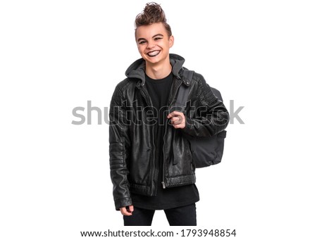 Portrait of teen boy student with spooking make-up holds bag, isolated on white background. Teenager with backpack in style of punk goth dressed in black. Problems of transitional age.