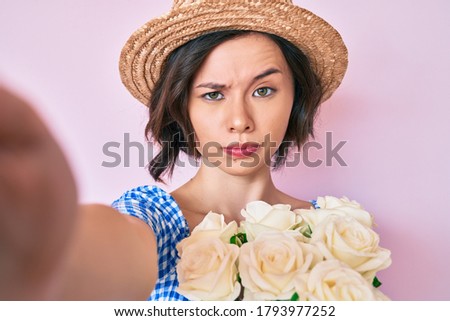 Young beautiful girl wearing summer hat taking a selfie skeptic and nervous, frowning upset because of problem. negative person. 