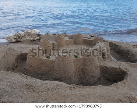 Sand castle on the beach by the sea in summer