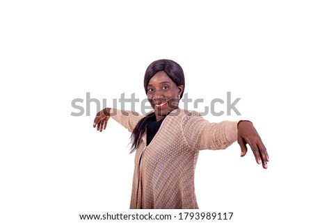 portrait of a beautiful mature African woman raising her arms while smiling looking at the camera.