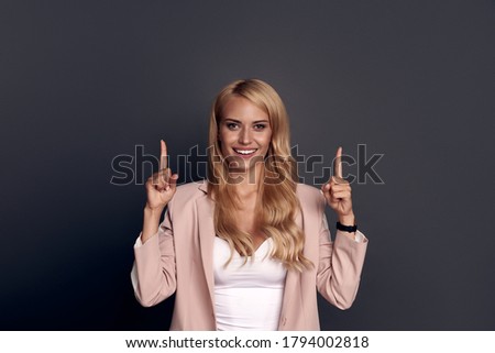 Portrait of positive cheerful business lady point index finger copy space present ads promotion, recommend select suggest wear good look clothes isolated over grey color background.