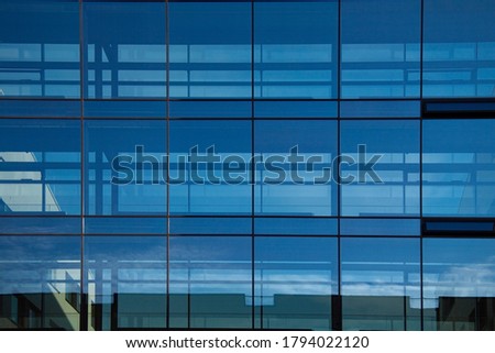 Part of geometric glass facade from modern office building with reflections. Image with copy space.