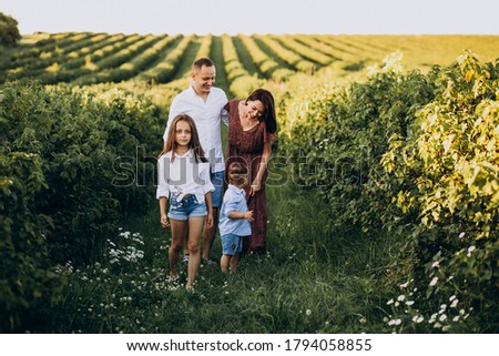 Young family with kids having fun in a field