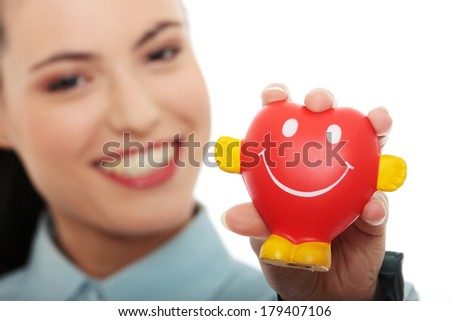 Young business woman holding heart shaped toy