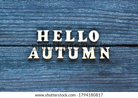 Hello Autumn. Goodbye, Summer. The word autumn is written in wooden letters on a wooden background.Autumn seasons greeting card. Atmospheric image. The concept of the autumn advertising.