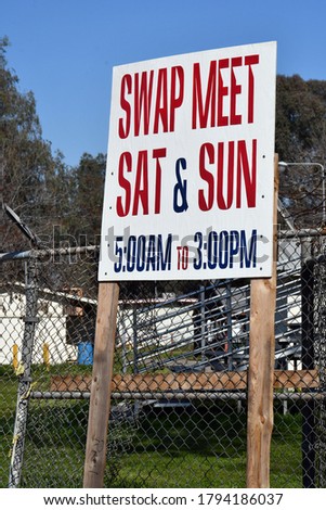 A swap meet sign telling the hours