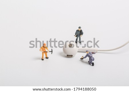 Headphones and miniature workers on white background