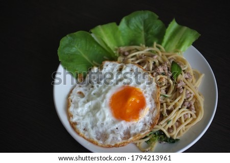 Spaghetti stir fried with Thai Basil spicy sauce with Fried egg  , fusion Thai style , space for text