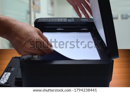 close up photo of a person wearing white paper on a black scanner.on the table