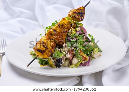A view of a plate of chicken kabob salad.