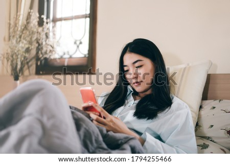 Lifestyle with modern technology concept. Young adult lonely single woman using smartphone in the moring for social message app chat with friend for mental health. Royalty-Free Stock Photo #1794255466