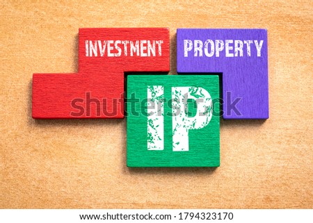 IP. Investment and Property concept. Colored wooden blocks, puzzle and mind game. Orange background