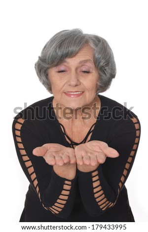Senior woman in black dress giving something