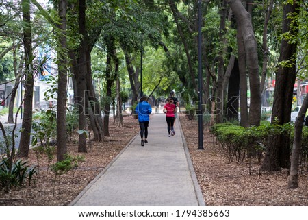 Runners in the lush green park island medians of Avenida Amsterdam in the trendy neighborhood of Condesa, in Mexico City (Ciudad de Mexico, CDMX). Royalty-Free Stock Photo #1794385663