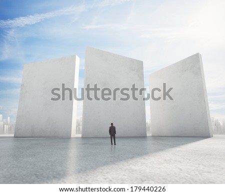 Businessman looking at three cement blank banners and city on horizon