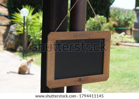 Blackboard with wooden frame in a rural setting.