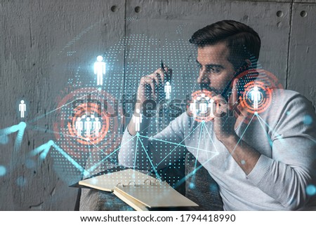 Handsome SMM manager in casual wears, speaking phone, taking notes at office try to determine customer needs to launch social media project. Double exposure. The concept of successful online business. Royalty-Free Stock Photo #1794418990