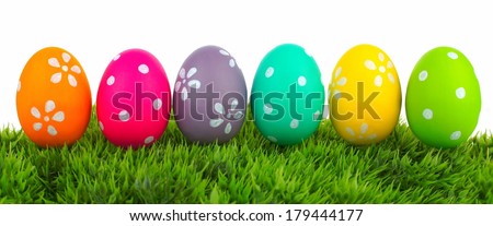 Row of Easter eggs on grass with a white background