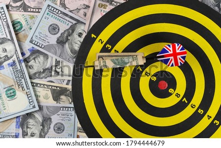 American dollars, banknotes, cash money pile with dartboard target and throwing dart background and texture