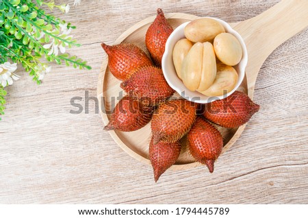 Salak Palm , waive or snake fruit in wooden dish on the table.