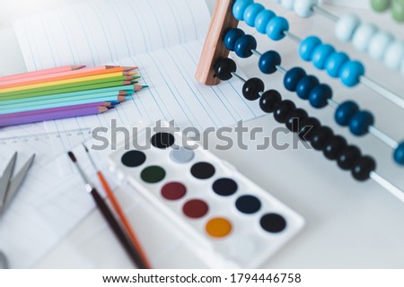 Back to school. Items for the school on a blue wooden table. School supplies on white board background. Back to school concept.