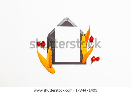 Top view composition of black blank post mail envelope mock up with a autumn yellow and red leaves background