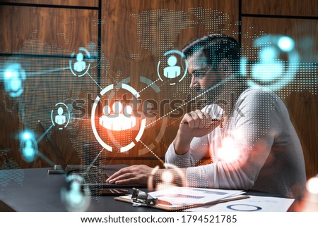 A serious caucasian manager in casual wears, using laptop to develop a new network. Double exposure. Social media hologram.