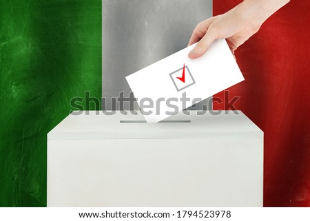 italian Vote concept. Voter hand holding ballot paper for election vote on polling station